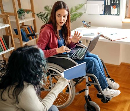 Student in wheelchair studying with roommate