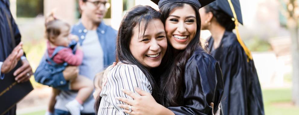 Nursing school graduate hugging her mom at commencement