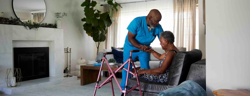 Home health nurse assisting elderly patient