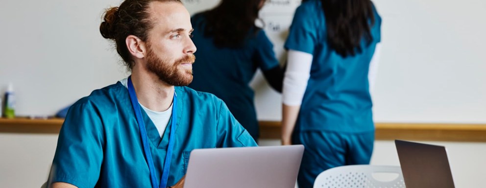 Nurse working in conference room, looking tired and sad