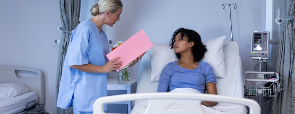 Travel nurse talking to patient in hospital bed