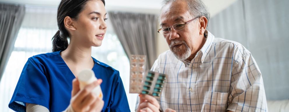 Nurse administering medication to senior man