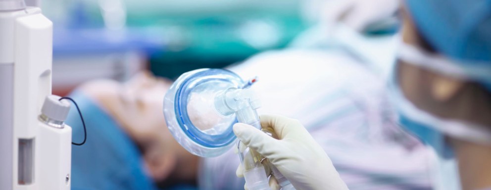 Nurse anesthetist holding mask