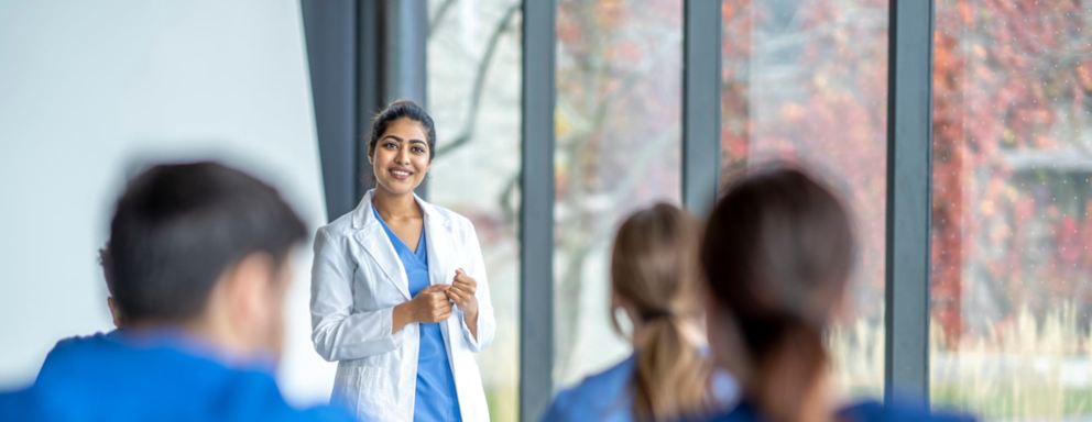 Nursing lecturer talking to students in classroom