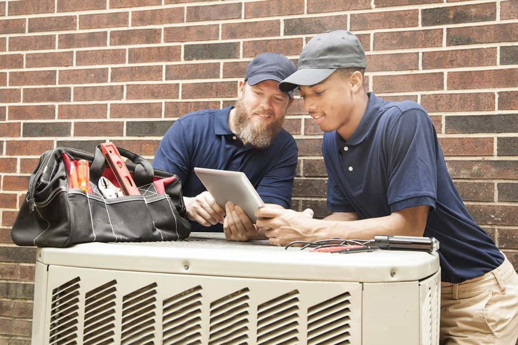 Student apprentice works on an HVAC unit.