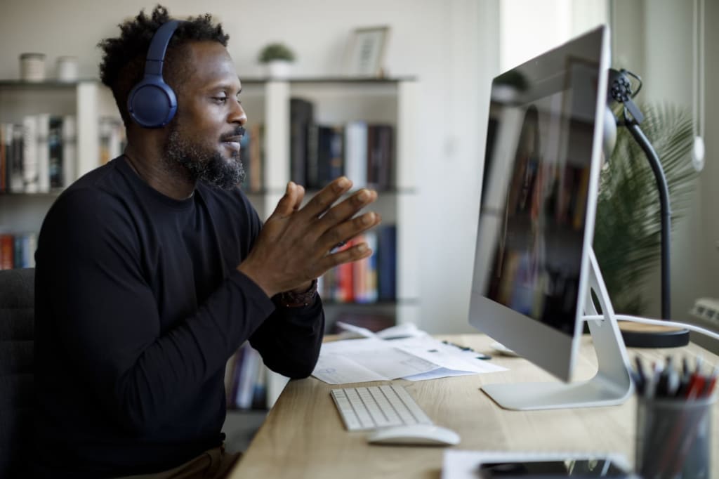 Smiling man with headphones having video call at home office