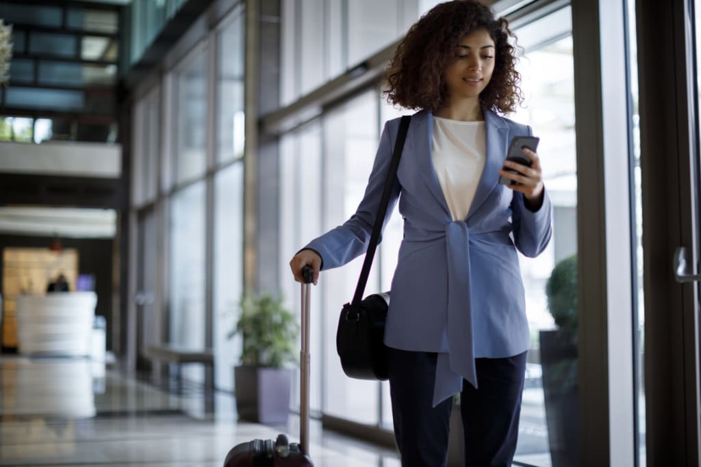 Business woman pulling suitcase through airport
