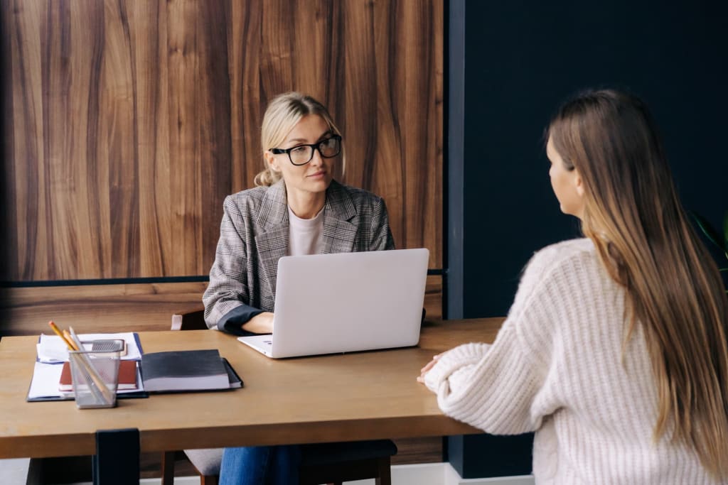 Young woman being interviewed at a desk
