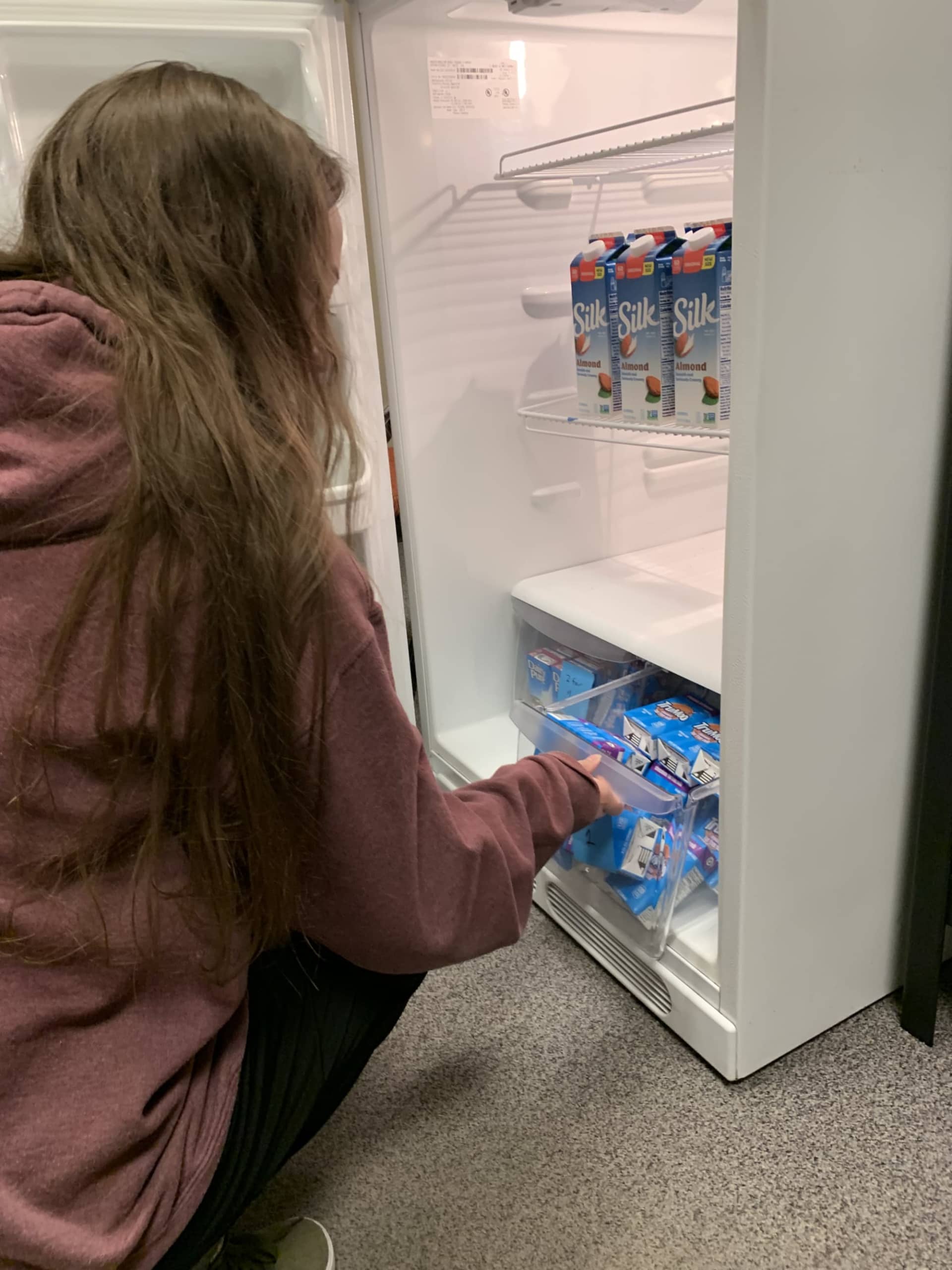 Stocking a fridge at the food pantry.