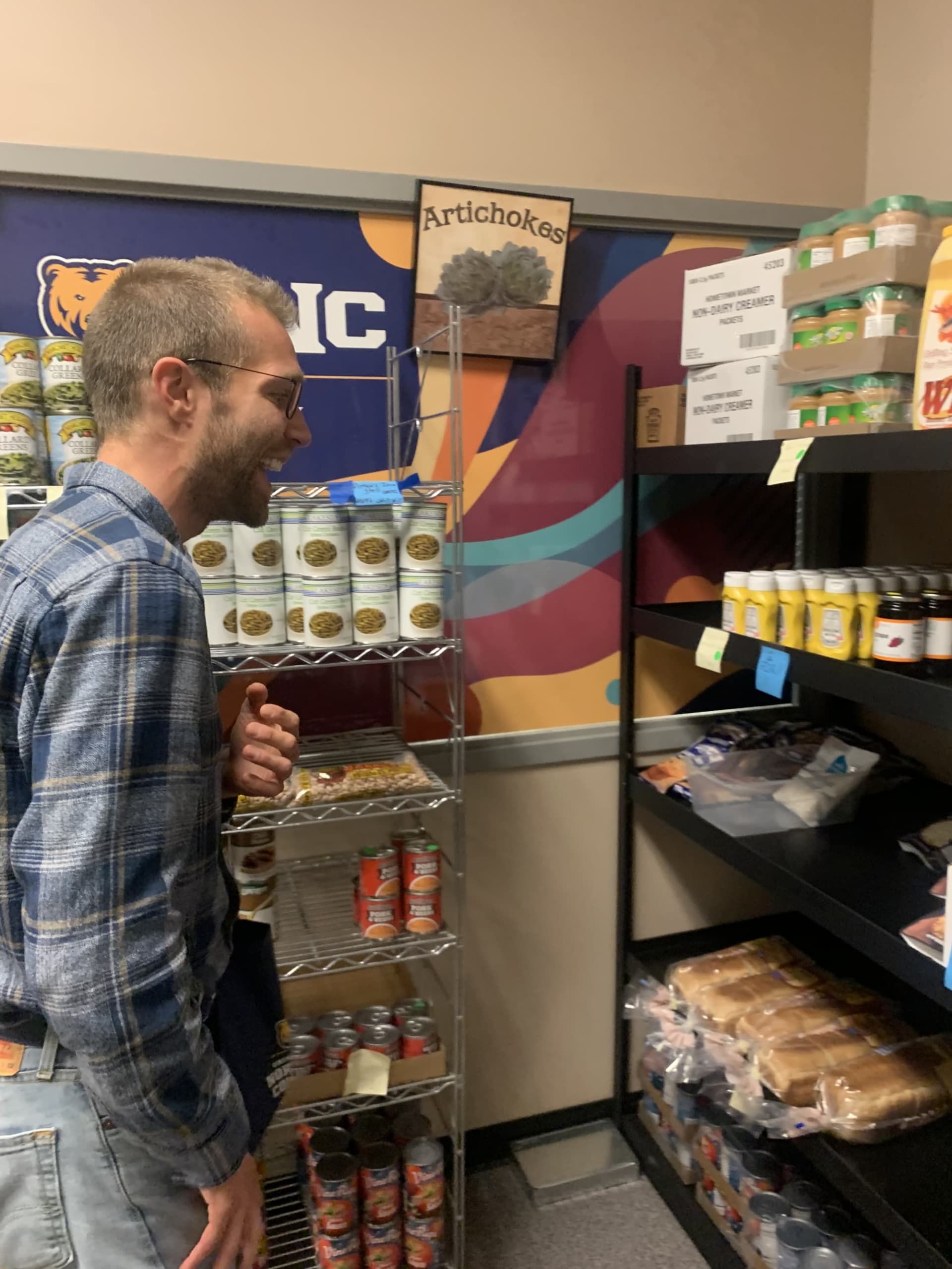 Student looks over shelves at food pantry.