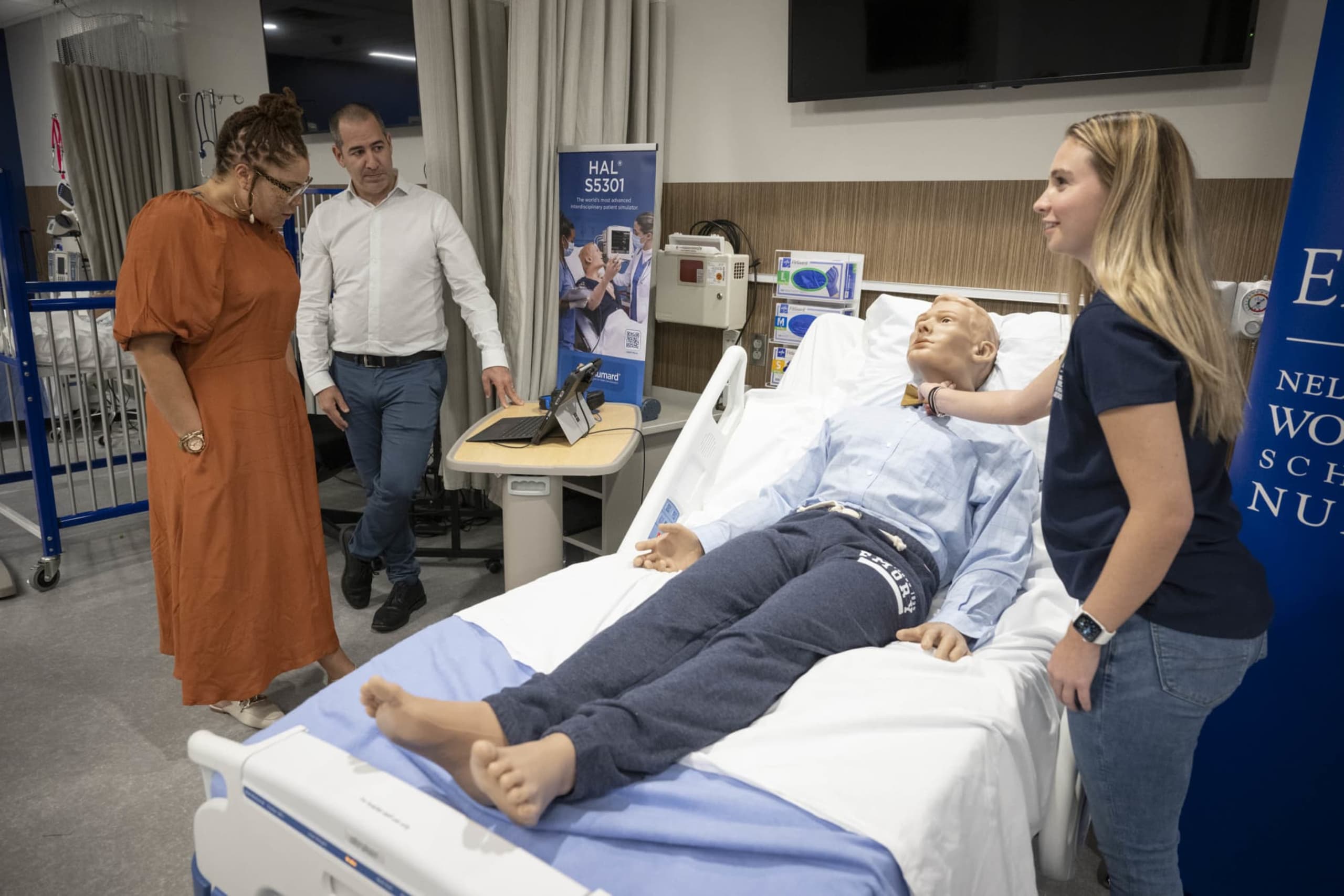 Three people examining Emory HAL patient simulator