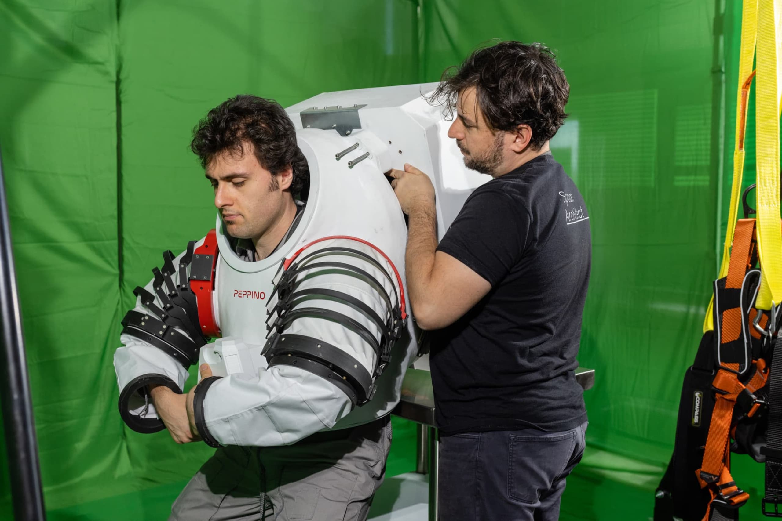 Netti helping Mangili put on his space suit in the mixed reality lab