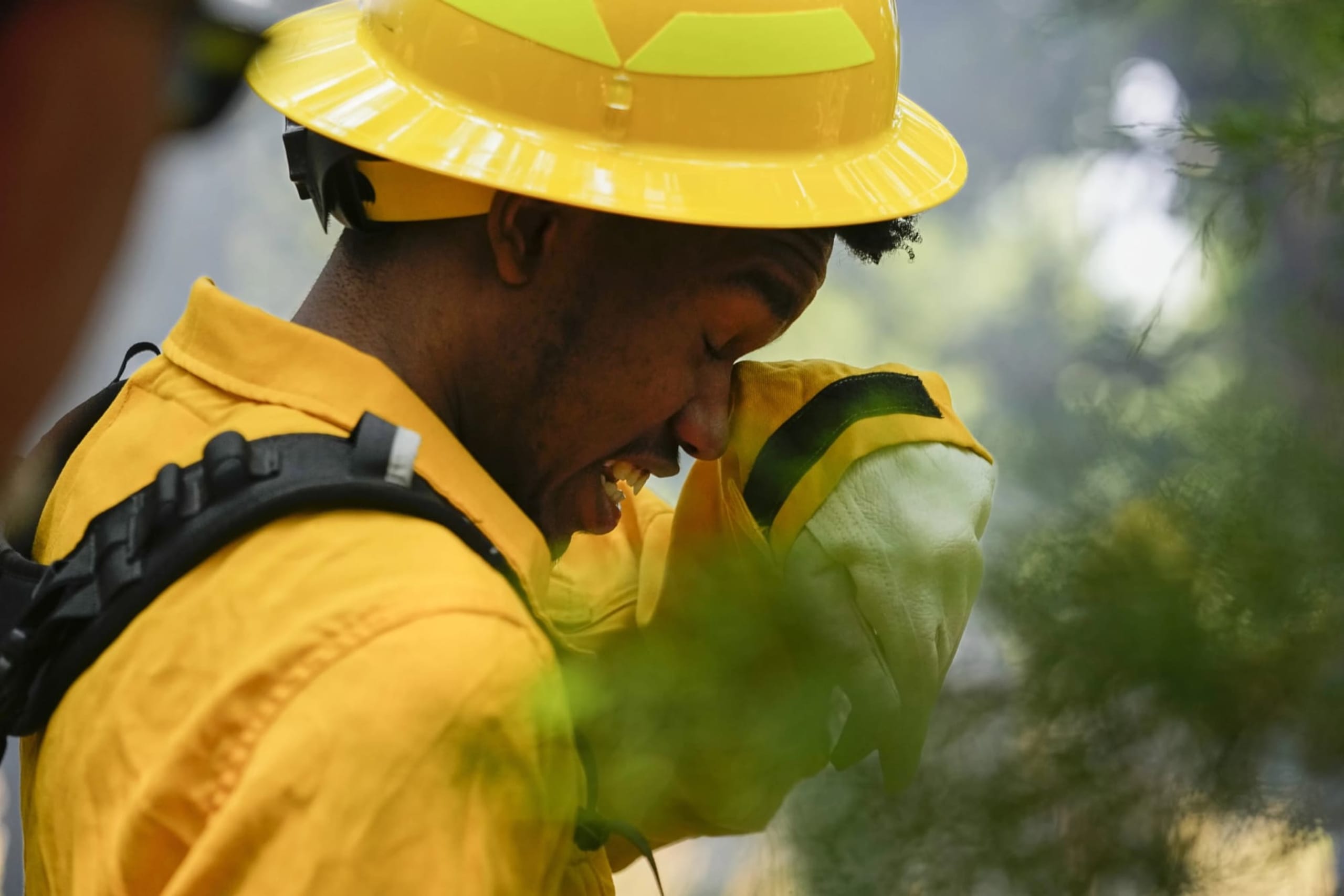 A FireDawg student wiping his eye in the midst of smoke.