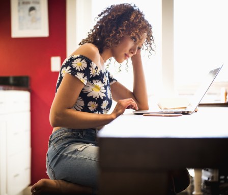 Woman studying on laptop in kitchen