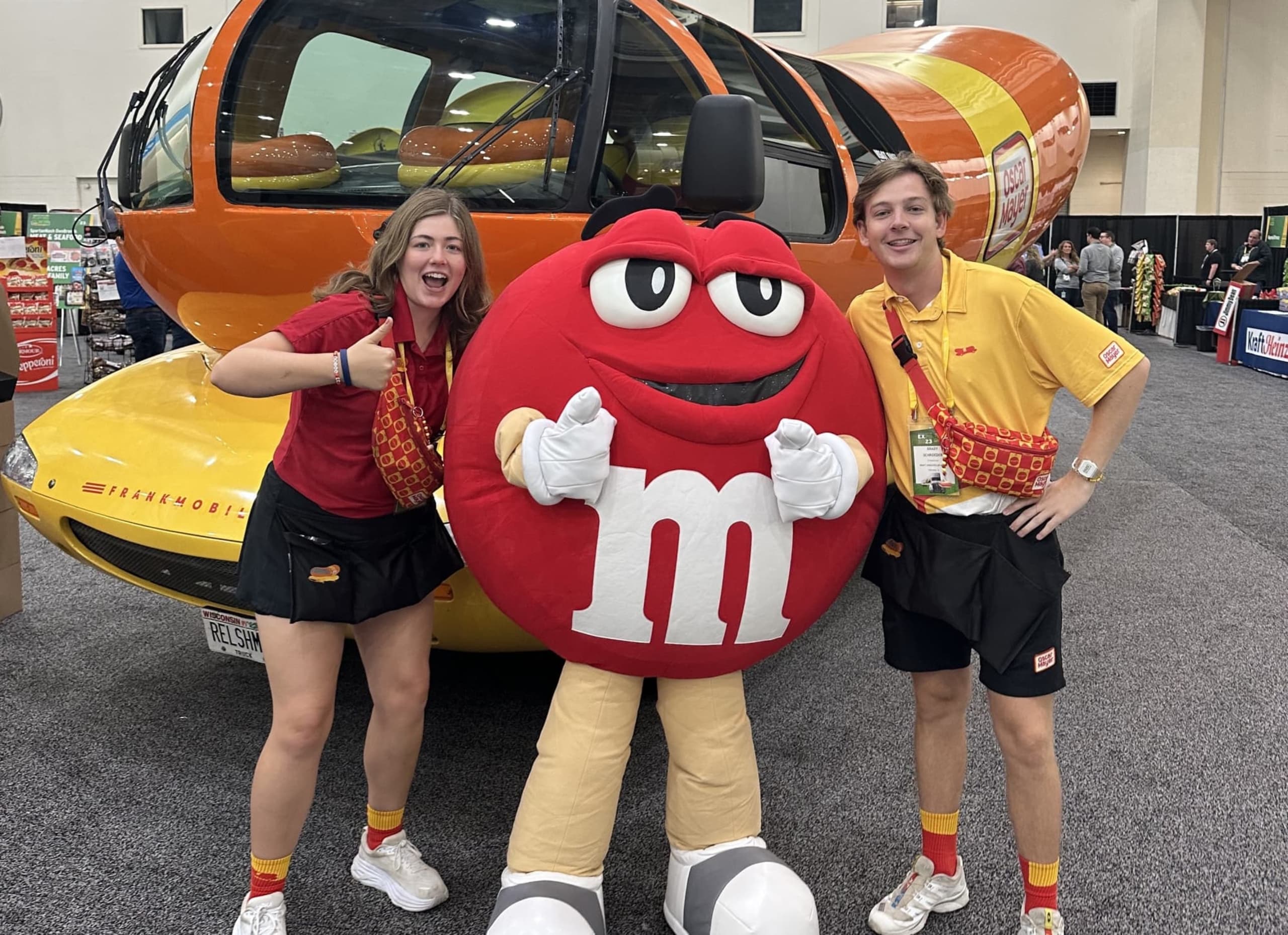 Students posing with M&M mascot in front of Frankmobile