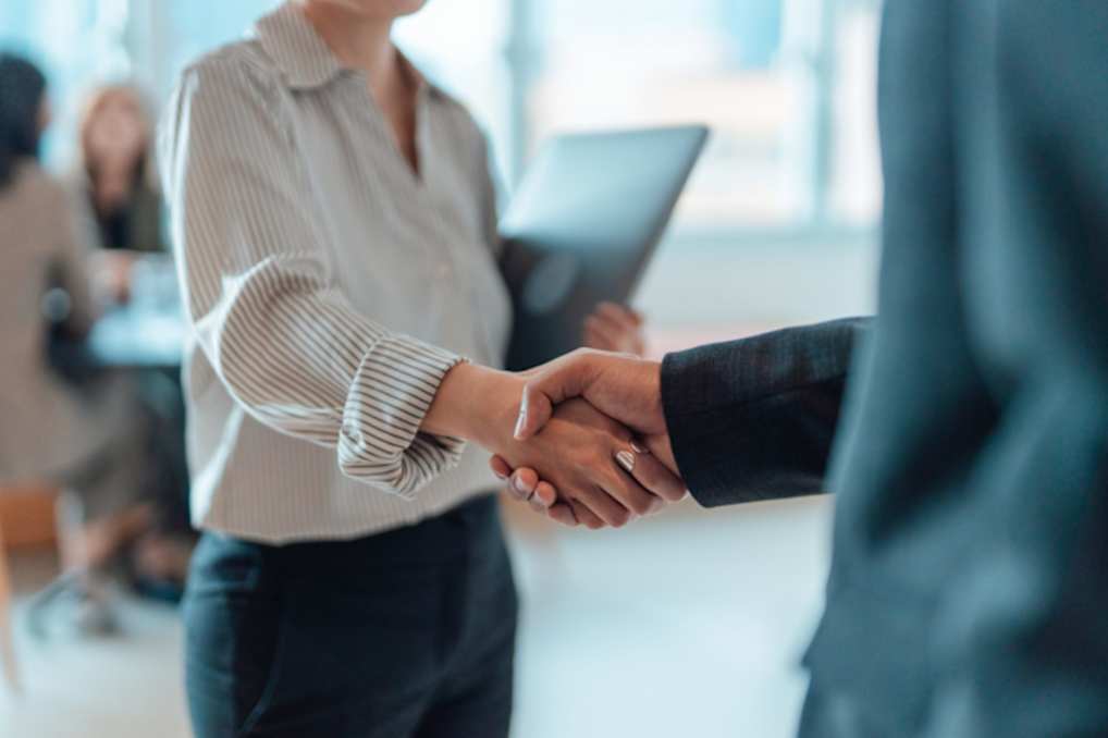Two professionals shaking hands in a workplace