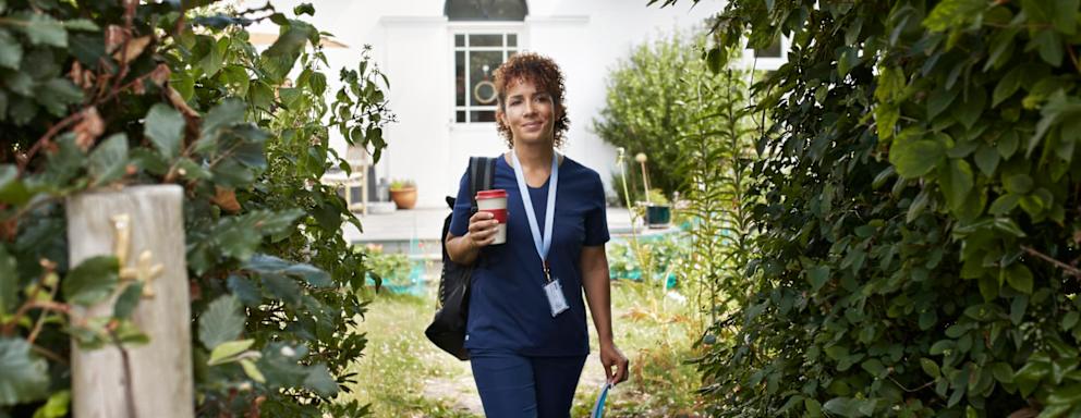 Nurse carrying lunchbox while walking outside