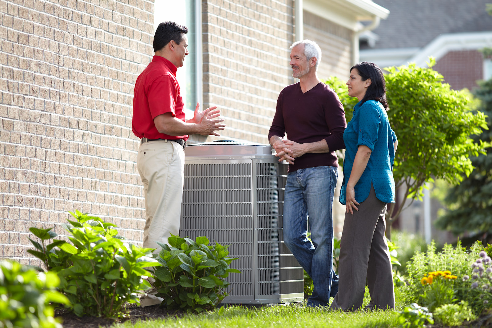 Bryant technician talking with homeowner while checking air filter and furnace