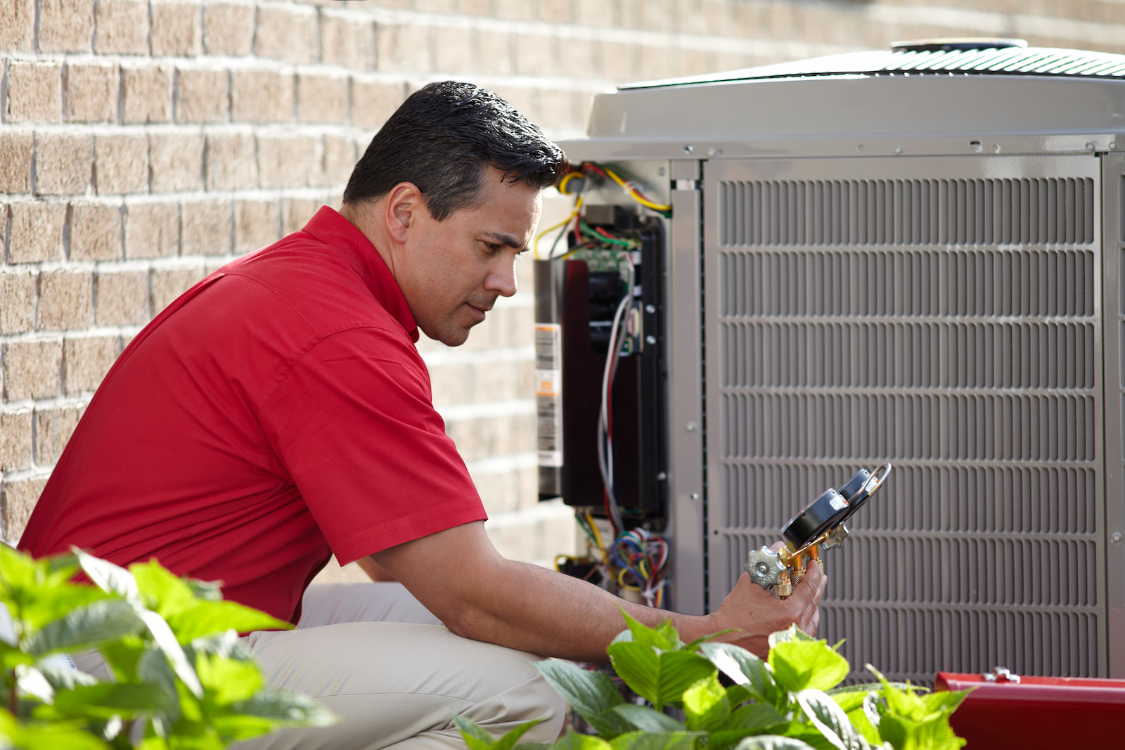 Bryant technician talking with homeowner while checking air filter and furnace