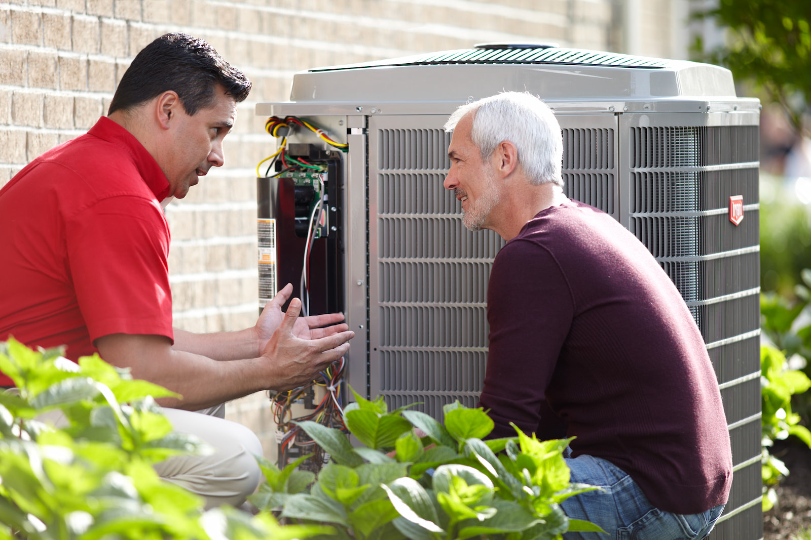 Bryant technician talking with homeowner while checking air filter and furnace