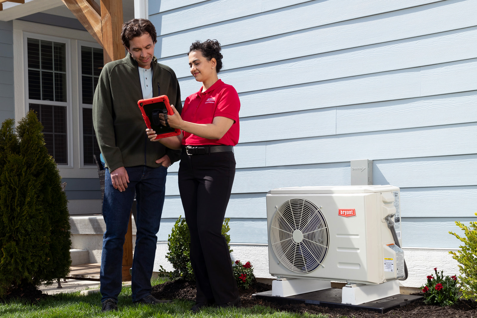 Bryant technician talking with homeowner while checking air filter and furnace