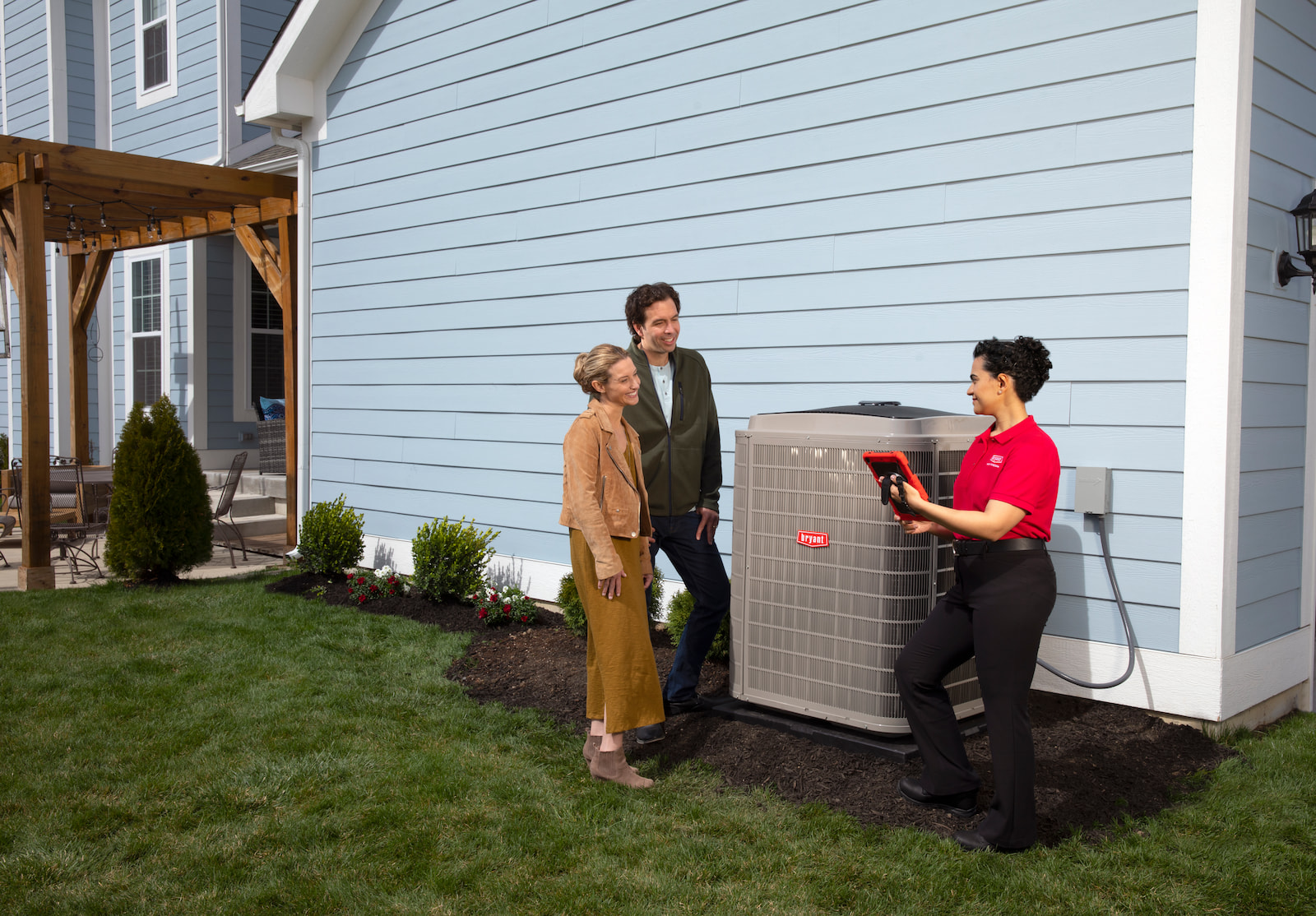 Bryant technician showing a couple their new air conditioner