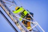 Closeup of a student climbing down a silver fire truck ladder.