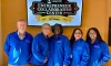 The BRAC team in blue jackets standing under the ECC Celebrating 10 Years sign