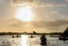 Kayakers and canoers enjoy the golden-hour sky during an Edward Medard Conservation Park Sunset Paddling Tour.