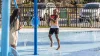 Two kids are playing in the splash pad