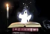 Glowing, shining ghost figure, rising from a book in a magical still life with a lit candle.