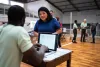 Volunteer talking with a woman while using the laptop at an emergency recovery location