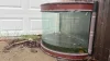 Old fish tank with several inches of rainwater where mosquitoes can breed
