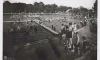 People lined up for the slide with lots of other people already in the very large pool