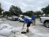 Men lifting sandbags into cars