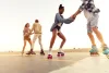 A diverse group of people roller skating outside as the sun sets