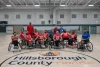 The Strong Dogs team photo on a court showing the Hillsborough County logo on the floor