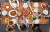 Overhead shot of a group of people sitting around a table eating a Thanksgiving meal