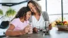 Mom and daughter snuggling while holding water glasses.