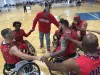 Wayne Bozeman is in the middle of a group of players on the basketball court