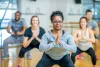 A diverse group of people in an exercise class doing what looks like a yoga pose