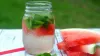 Watermelon and mint water in a mason jar next to some slices of watermelon