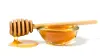 A honey wand sitting on top of a small bowl of honey