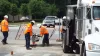 Employees using machinery to make the road repair