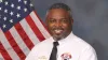 Tim Dudley in dress uniform in front of a US flag