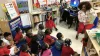 A classroom of children with a teacher reading to them