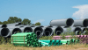 water and sewer pipes sitting in piles in a field