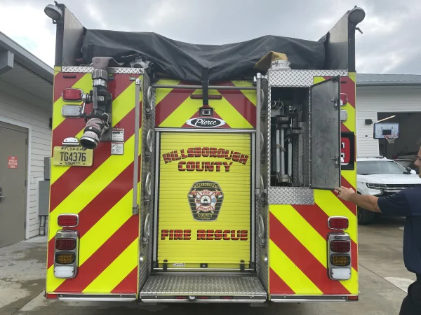 A folding ladder is stored in the back of this fire engine.