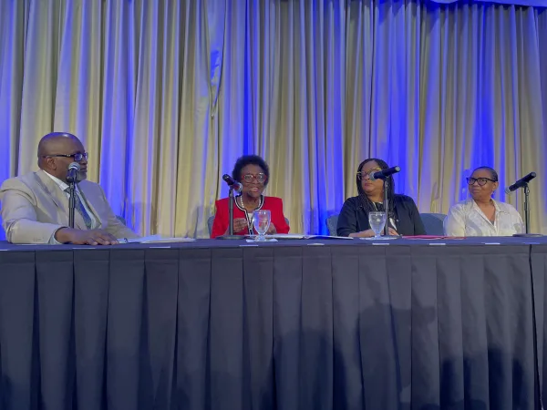 Four panelists sitting at a long table