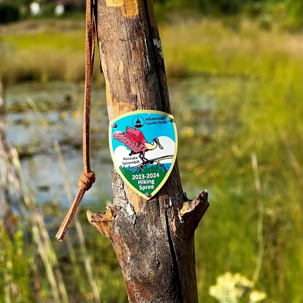 The Roseate Spoonbill medallion tacked to a tree